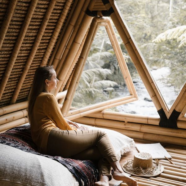 Person sitting in a meditation pose looking out a window.